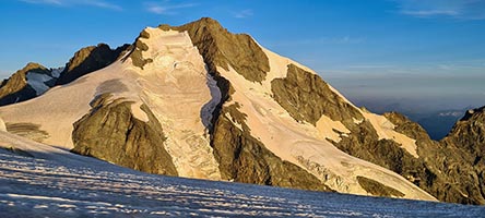 Il versante est del Bernina all'alba con la cresta Biancograt contro il cielo blu