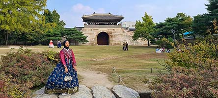 La porta di Geonchunmun nel palazzo di Gyeongbokgung con signora in costume tradizionale